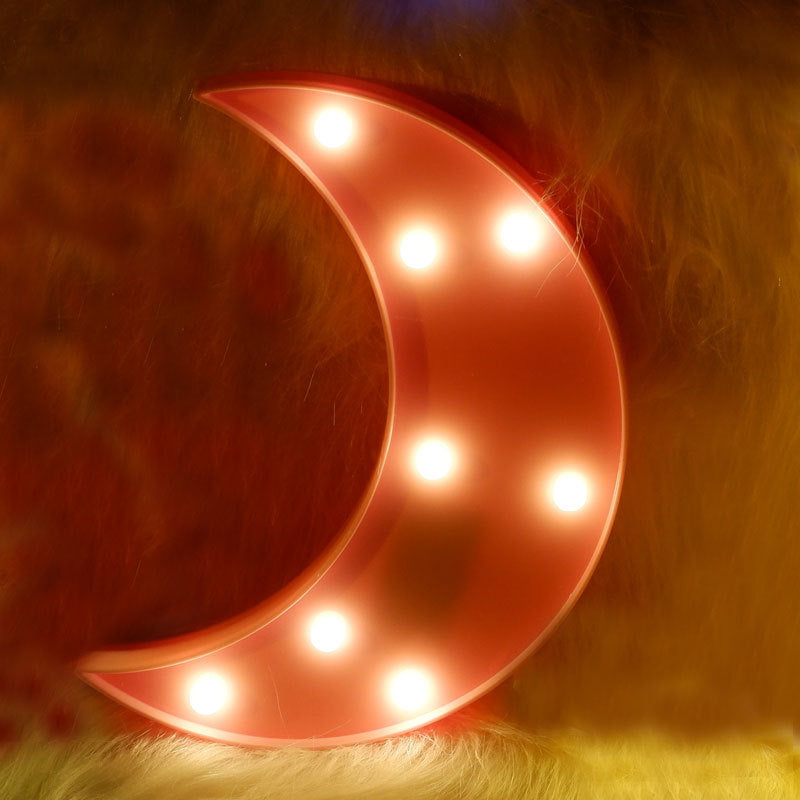 Decorative light shaped like a crescent moon on a soft surface