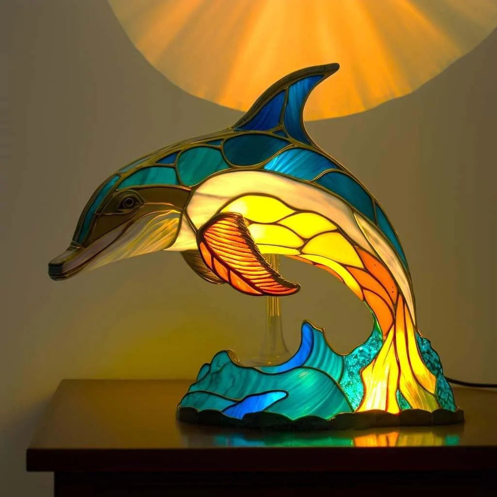 Stained glass dolphin lamp on a wooden surface with a warm light in the background.