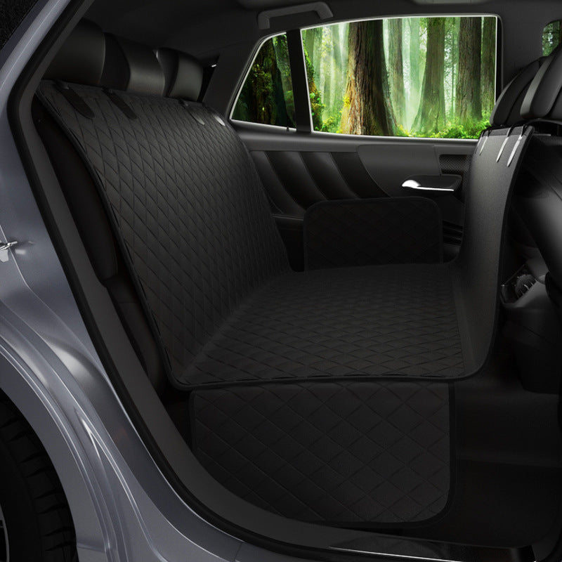 Car interior with black seat covers and a view of a forest through the window.