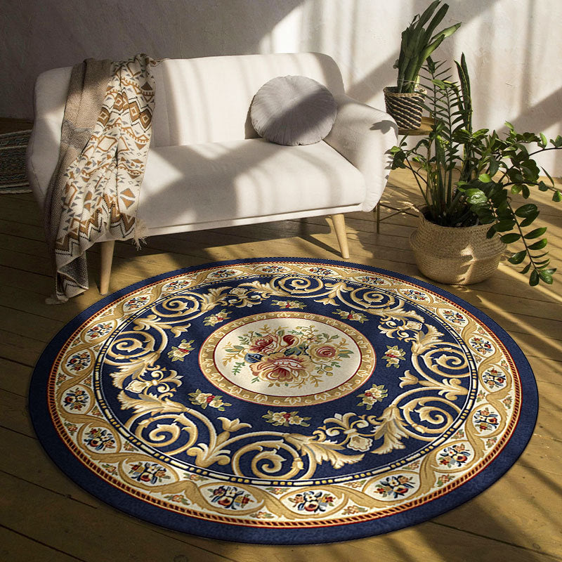 Decorative round rug with floral design in a room with a white sofa and plants.