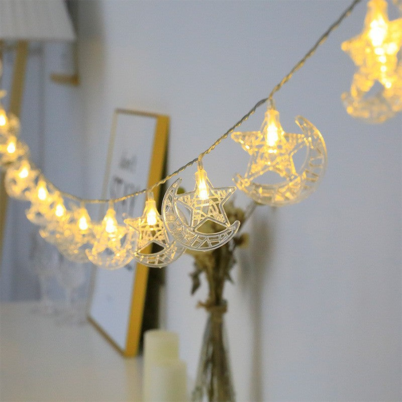 String lights with star and moon designs on a blurred indoor background