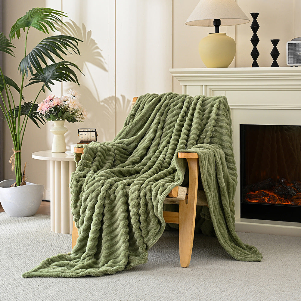 Green chunky knit blanket draped over a wooden chair in a cozy living room.
