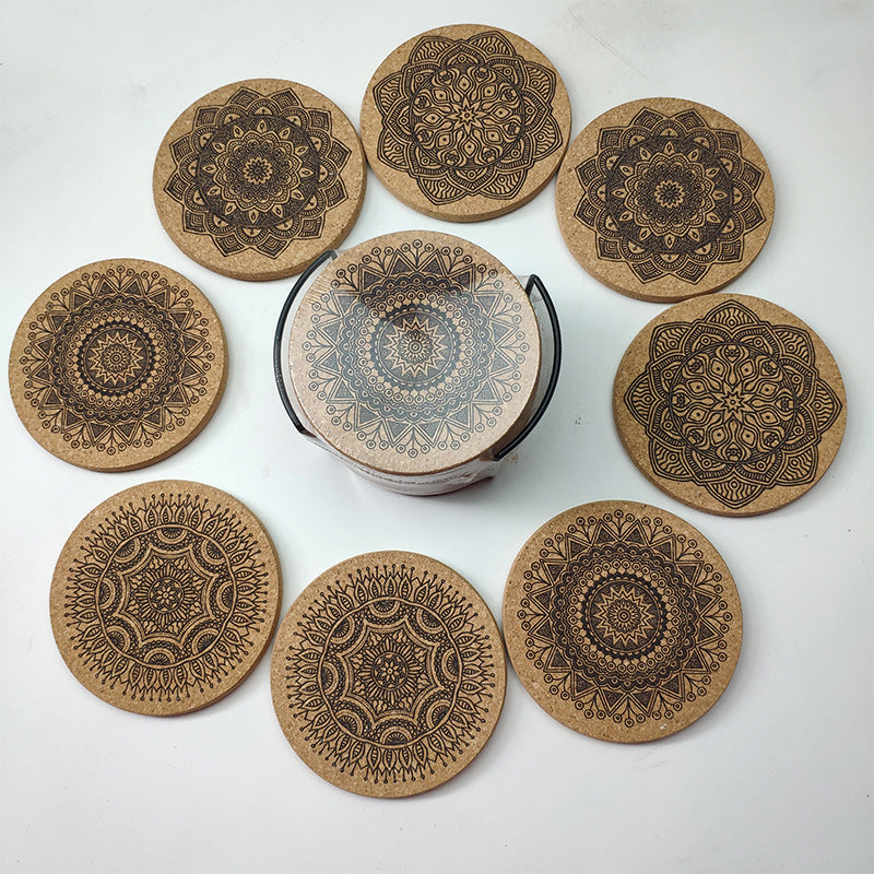 Set of eight cork coasters with mandala designs on a white surface