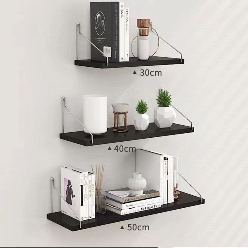 Set of three black wall shelves with decorative items on a white background