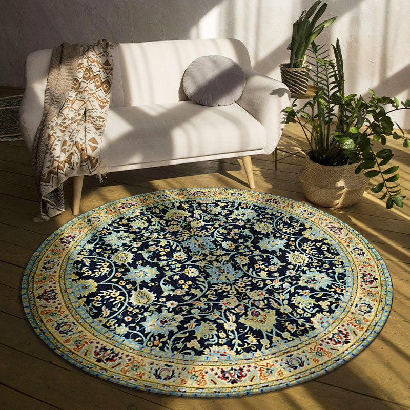Round floral rug in a living room with a white sofa and plants.