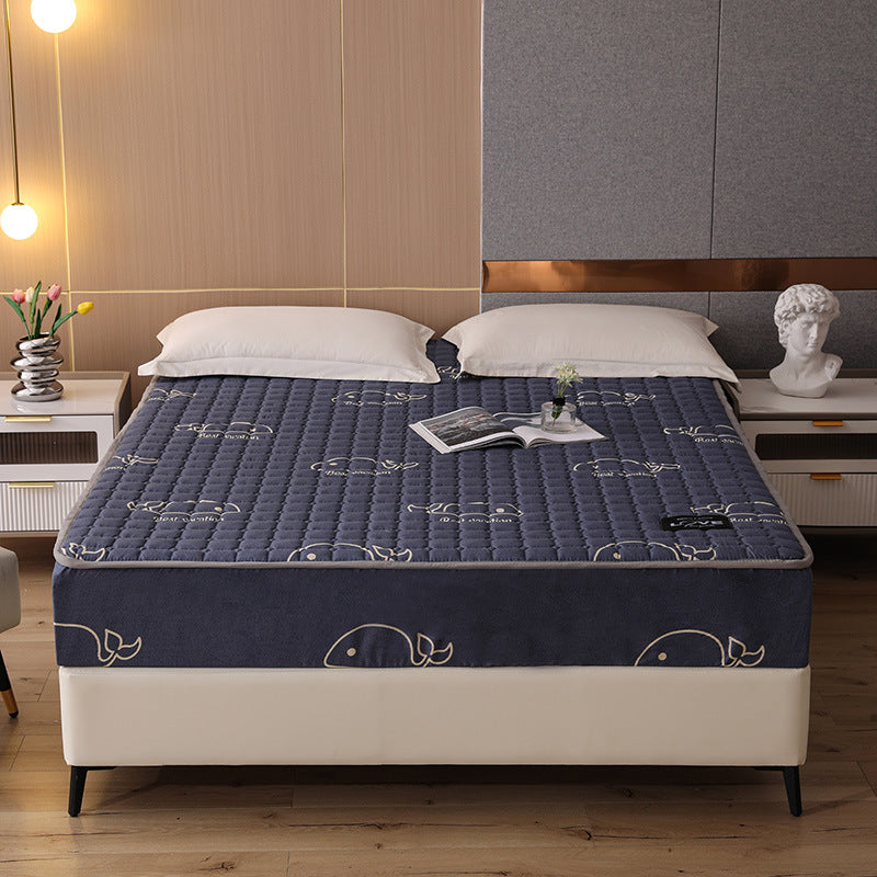 Blue mattress cover with whale pattern on a bed in a bedroom setting.