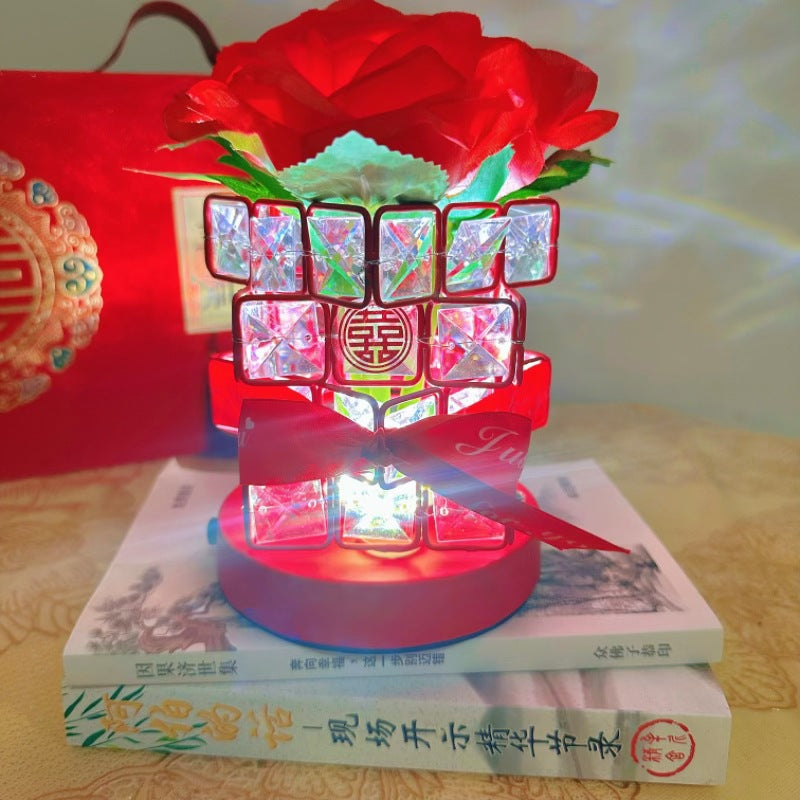 Decorative light with red and white design on books, featuring a red bow.