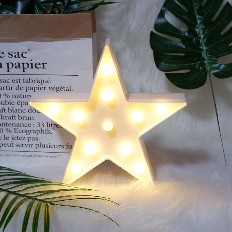 Star-shaped light fixture on a surface with text and leaves in the background